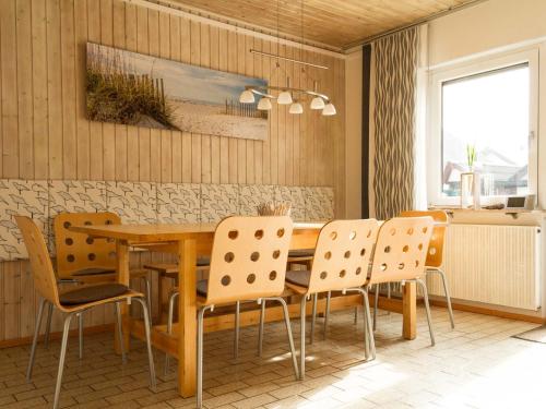 comedor con mesa de madera y sillas en Apartment Muggensturm am Badesee en Muggensturm