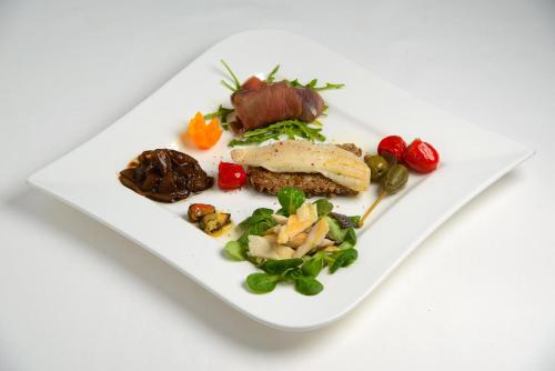 a white plate of food on a white table at Vila White in Trogir