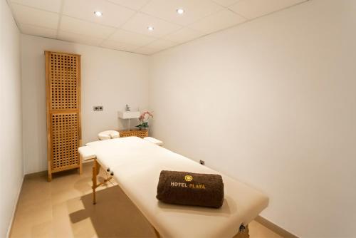 a white room with a bed with a brown bag on it at Hotel Eden Palma Playa Adults Only in Can Pastilla
