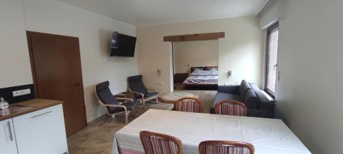 a kitchen and a living room with a table and chairs at La Diligence in Arsdorf