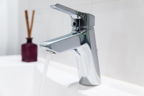 a kitchen sink faucet with water dripping from it at Ténéo Apparthotel Talence - Arthena in Talence