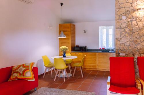 a kitchen with a table and yellow and red chairs at Quinta da Aurora in Évora