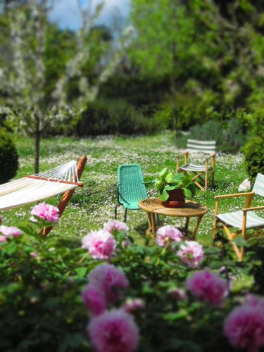 a group of chairs and tables in a yard with flowers at B&B Tobia in Cave
