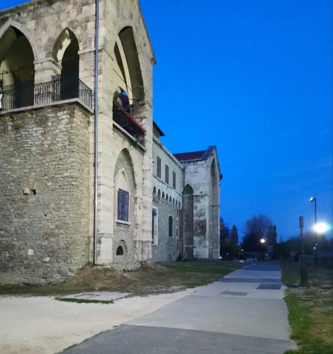an old stone building with a balcony on the side at Panzió Tata in Tata