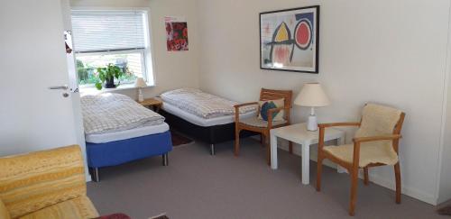 Cette chambre comprend un lit, une table et des chaises. dans l'établissement Brovst bed and breakfast, à Brovst