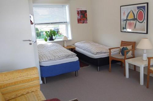 a room with two beds and a table and a window at Brovst bed and breakfast in Brovst