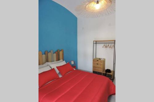 1 dormitorio con cama roja y pared azul en Blue Sail Apartment, en Termoli