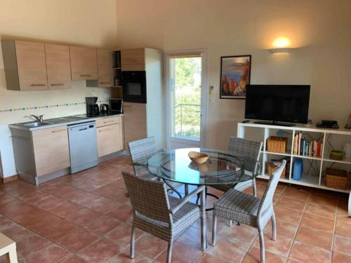 a kitchen and dining room with a table and chairs at Les Villas de Lava in Appietto