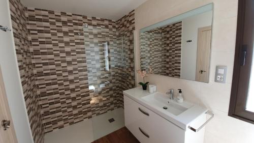 a bathroom with a white sink and a mirror at Villa BELLA on Golf in La Estancia, Caleta Fuste-Fuerteventura in Caleta De Fuste