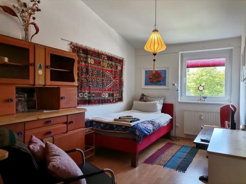 a bedroom with a bed and a desk and a window at Sunny and Lake in Krumpendorf am Wörthersee