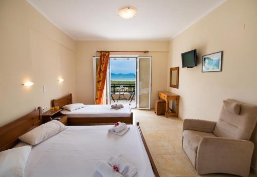 a hotel room with two beds and a couch at Calypso Luxury Studios in Vasiliki