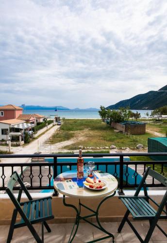 a table and chairs on a balcony with a view of the ocean at Calypso Luxury Studios in Vasiliki