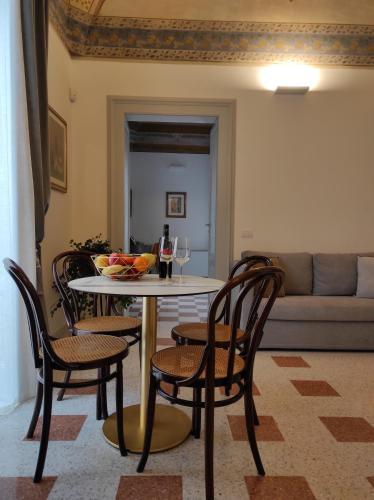 a table with a glass of wine and chairs at 1940 Luxury Accommodations by Wonderful Italy in Ostuni