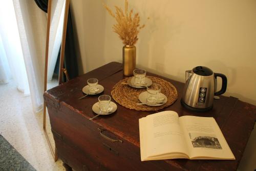 an open book on a wooden table with a tea kettle and cups at 1940 Luxury Accommodations by Wonderful Italy in Ostuni