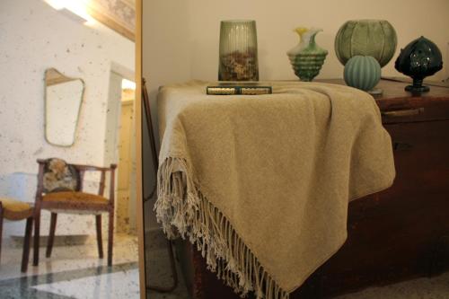 a table with a blanket on it next to a chair at 1940 Luxury Accommodations by Wonderful Italy in Ostuni
