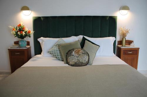a large bed with a green headboard and pillows at 1940 Luxury Accommodations by Wonderful Italy in Ostuni