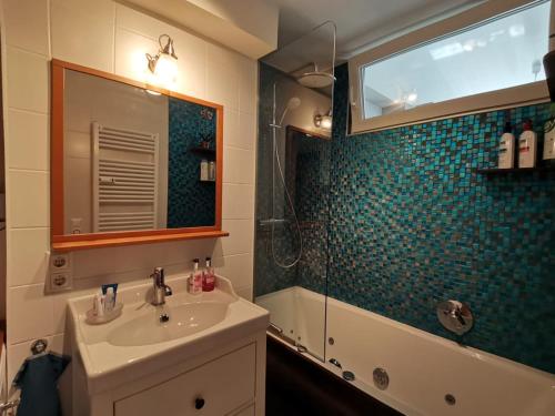 a bathroom with a sink and a shower and a mirror at Sunny and Lake in Krumpendorf am Wörthersee