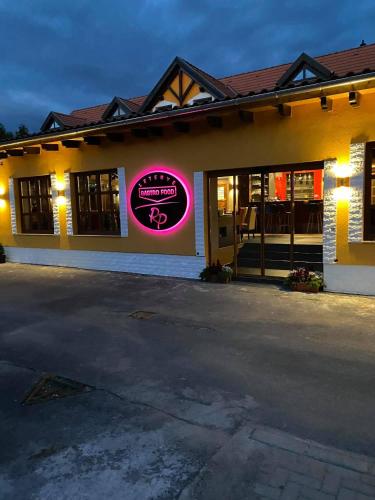a restaurant with a sign on the side of a building at Radics Panzió Étterem és Pihenő Központ in Letenye