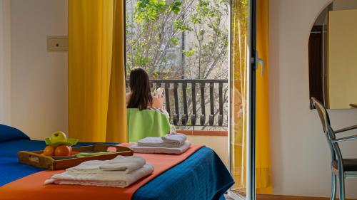 a little girl looking out the window of a room at Hotel Plaza con piscina in Cattolica