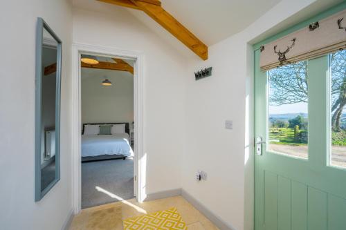 um quarto com uma cama e uma porta verde em Cart Shed Cottage em Truro