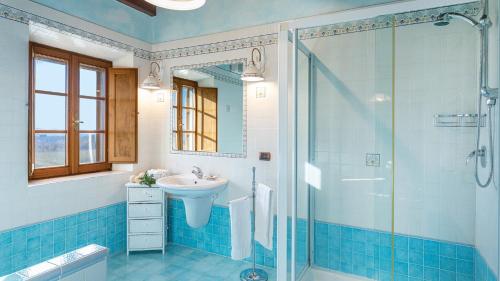 a bathroom with a sink and a glass shower at Villa Siena 10, Emma Villas in Castelnuovo Berardenga