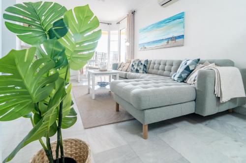 sala de estar con sofá y planta en 2-Bedroom Retreat with Stunning Views in Aldea Blanca with Private Paddle Court, en Marbella