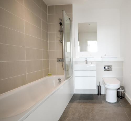 a bathroom with a tub and a toilet and a sink at Leicester City Apartments by Charles Hope in Leicester