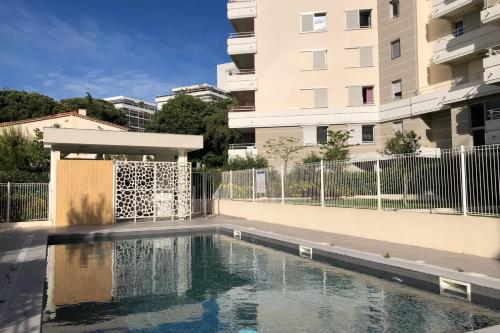 a swimming pool in front of a building at Appartement Danaé Antibes in Antibes