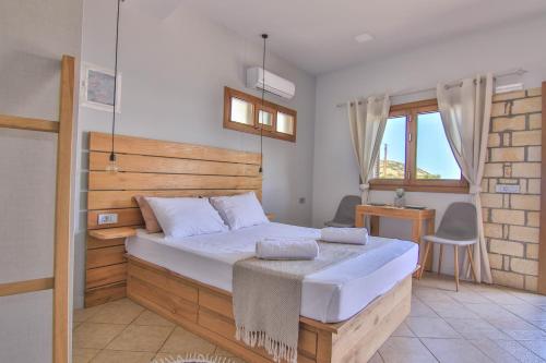 Schlafzimmer mit einem großen Bett mit einem Kopfteil aus Holz in der Unterkunft The Wave House in Mochlos