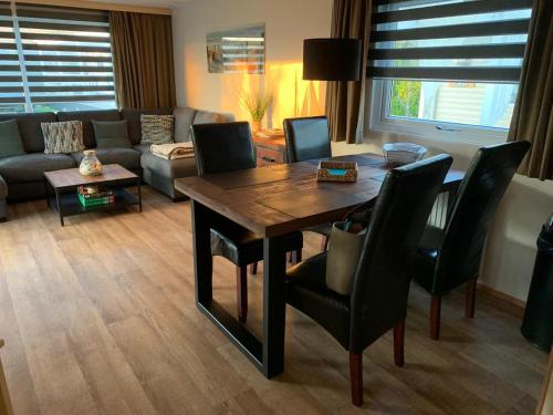 ein Wohnzimmer mit Tisch, Stühlen und Sofa in der Unterkunft RBR 655 - Beach Resort Kamperland in Kamperland