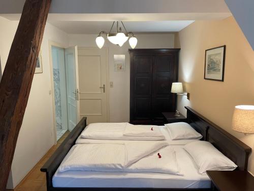 a bedroom with a large bed with white sheets at Gasthof zum Goldenen Löwen in Ehrenhausen