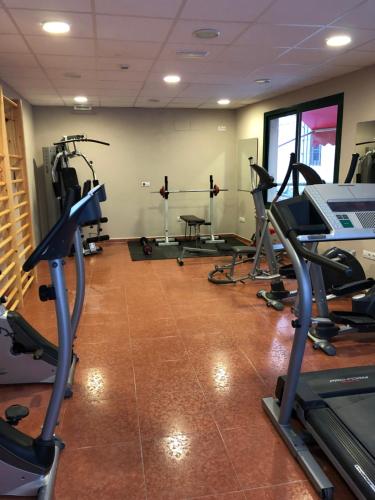 a gym with several tread machines in a room at Hotel Balneario de La Virgen in Jaraba
