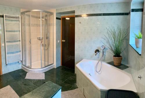 y baño grande con bañera y ducha. en Ferienwohnung Charline en Waren