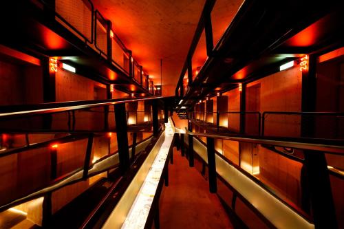 Zero Box Lodge Coimbra في كويمبرا: ممر طويل مع أضواء حمراء في مبنى