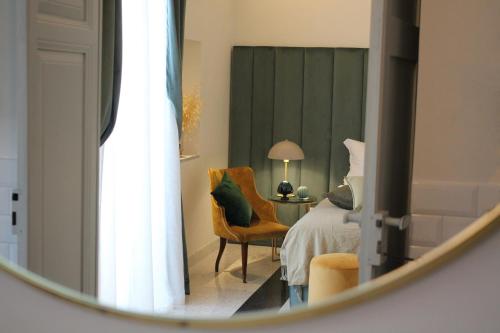 a reflection of a bedroom with a bed and a chair at 1940 Luxury Accommodations by Wonderful Italy in Ostuni