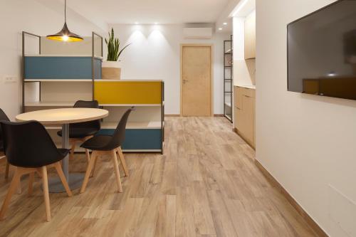 a dining room with a table and chairs and a tv at Apartamentos Isaga in Zarautz