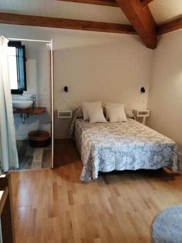 a bedroom with a bed and a bathroom with a sink at O Recuncho de Celia in Foz