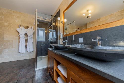 a bathroom with four sinks and a large mirror at Crossways in Wells