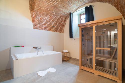 La salle de bains est pourvue d'une baignoire et d'un mur en briques. dans l'établissement NA KNÍŽECÍ CESTĚ VALTICE, à Valtice