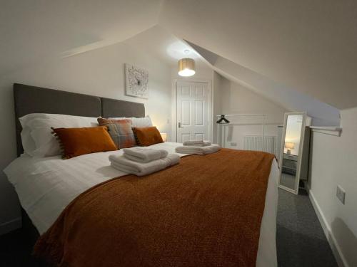 a bedroom with a large bed with towels on it at The Old Stables 17a in Dumfries