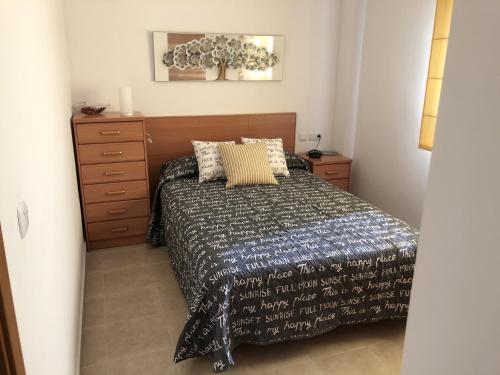 sypialnia z łóżkiem i komodą w obiekcie Apartamento junto al mar Los Marineros con acceso independiente por terraza w mieście Puzol