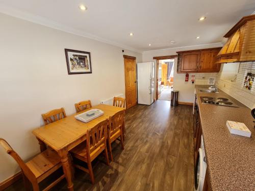 cocina y comedor con mesa de madera en Coach House en Penrith