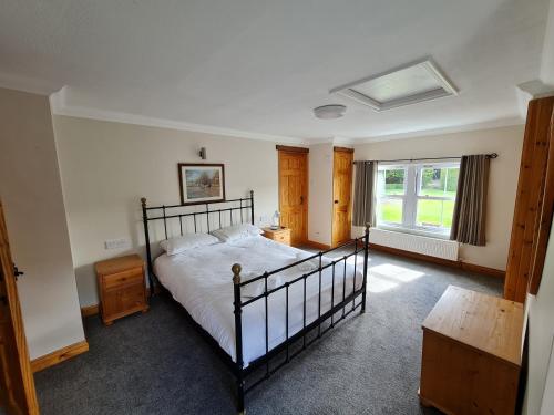 a bedroom with a large bed and a window at Coach House in Penrith