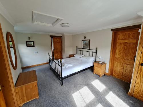 a bedroom with a bed and two wooden doors at Coach House in Penrith