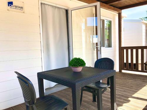 a black table and chairs on a porch at Camping Village Nice Garden in Ardea