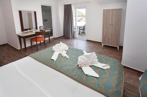 a hotel room with a bed with two white robes at London Hotel in Oludeniz