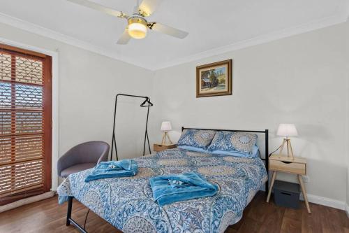 a bedroom with a bed with blue pillows on it at Hillview, a quiet country escape with views. in Yangan