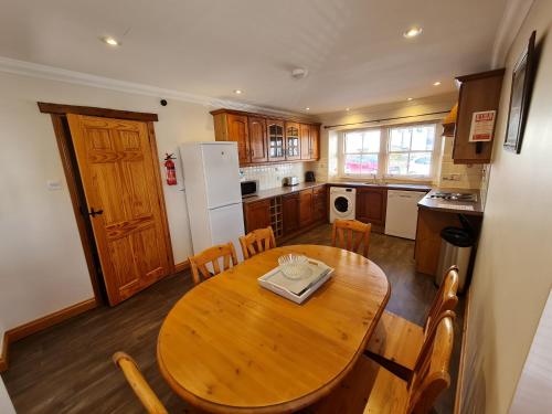 a kitchen with a wooden table and a table and chairs at Stable Cottage in Penrith