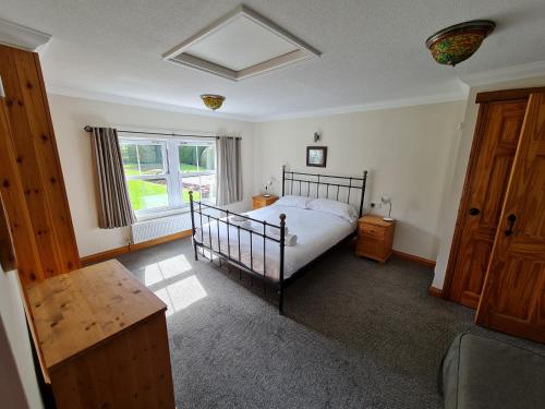 a bedroom with a bed and a large window at Stable Cottage in Penrith