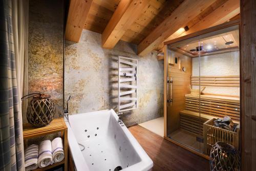 uma casa de banho com uma banheira e uma cabina de duche ao nível do chão em Chalety Horská Lúka Jasná em Demanovska Dolina
